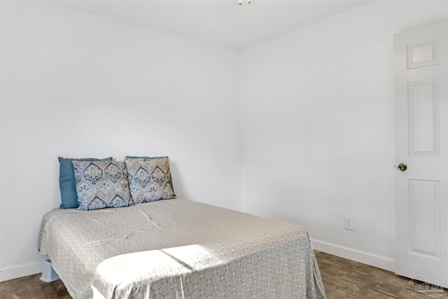 bedroom with dark wood-type flooring