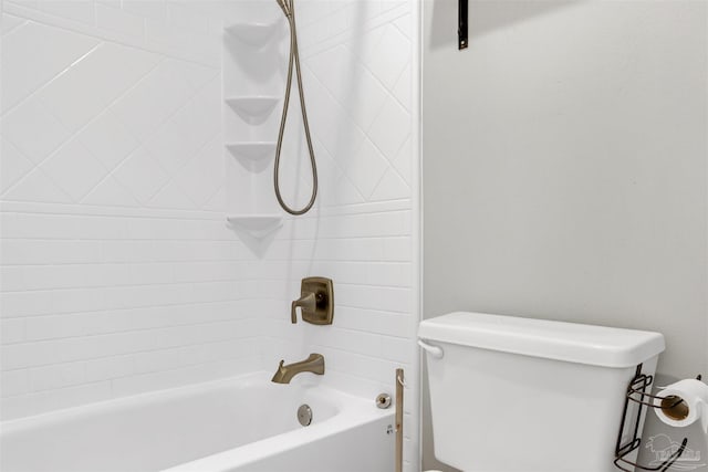 bathroom featuring toilet and tiled shower / bath