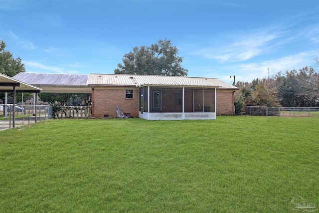 rear view of house with a lawn and a sunroom