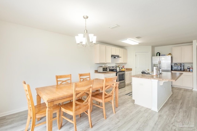 dining space featuring visible vents, light wood-style floors, and an inviting chandelier