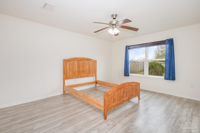 bedroom featuring visible vents, light wood-style floors, and baseboards