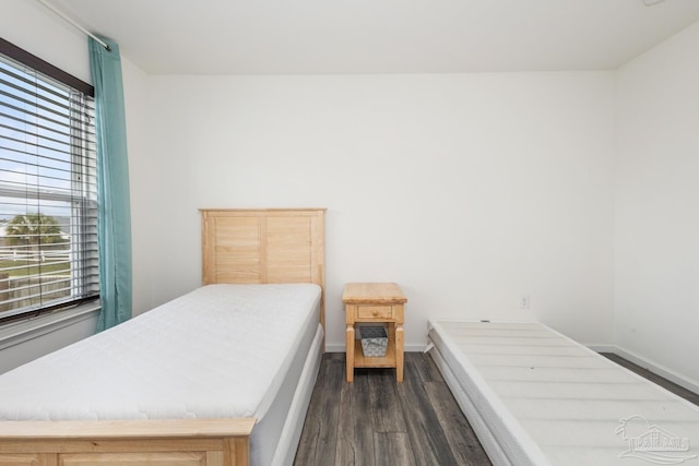 bedroom with dark wood-type flooring and baseboards