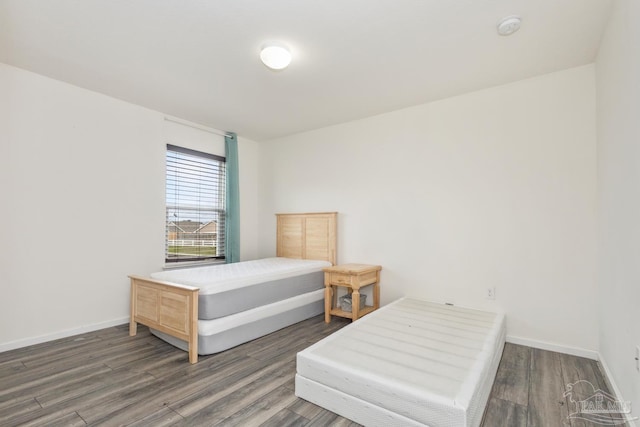 bedroom featuring baseboards and wood finished floors