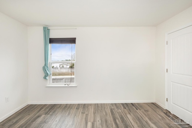 empty room with baseboards and wood finished floors