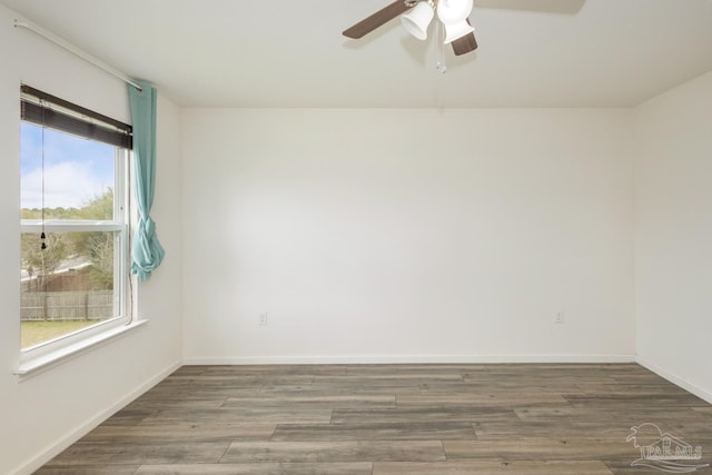 spare room with a ceiling fan, wood finished floors, and baseboards