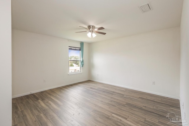 unfurnished room with visible vents, baseboards, a ceiling fan, and wood finished floors