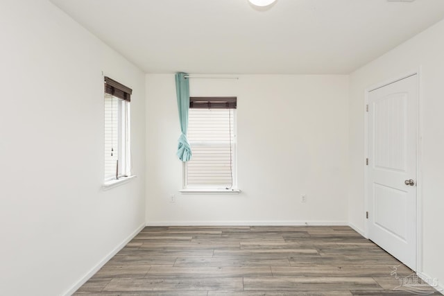 unfurnished room featuring baseboards and wood finished floors