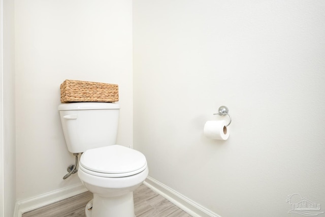 bathroom featuring baseboards, toilet, and wood finished floors