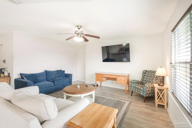 living area featuring a ceiling fan, light wood-style floors, and visible vents