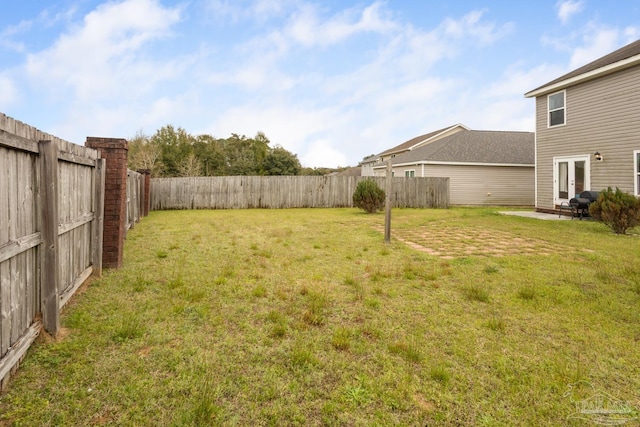 view of yard featuring french doors and a fenced backyard