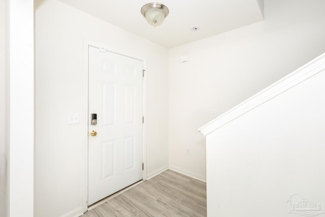 foyer entrance featuring light wood finished floors and baseboards