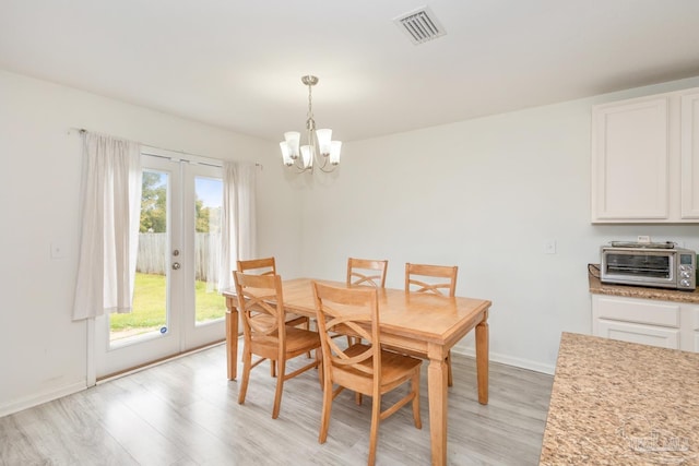 dining area with visible vents, baseboards, a toaster, light wood-style floors, and french doors