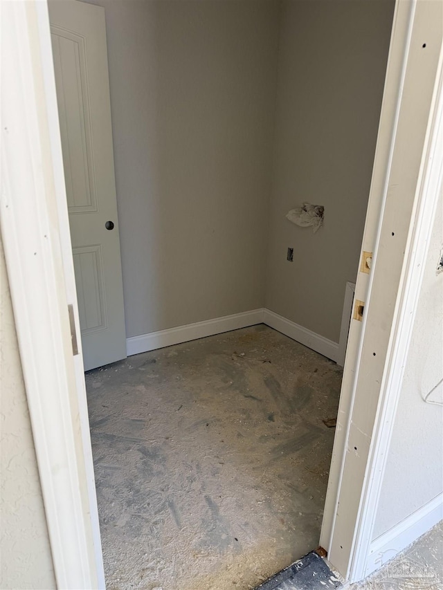 clothes washing area featuring baseboards
