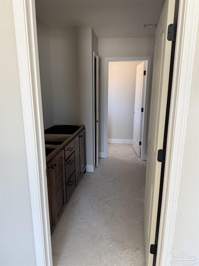 hallway featuring concrete floors and visible vents