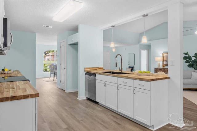 kitchen with white cabinets, butcher block counters, appliances with stainless steel finishes, and hanging light fixtures