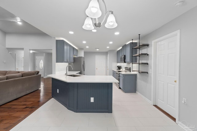 1052 Ashley Rd, Milton, FL 32583 - kitchen with appliances with stainless steel finishes, a peninsula, a sink, light countertops, and tasteful backsplash