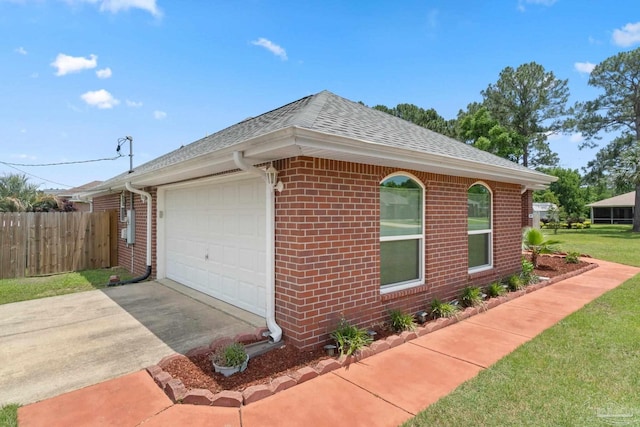 1052 Ashley Rd, Milton, FL 32583 - view of side of home featuring brick siding, a shingled roof, fence, an attached garage, and concrete driveway