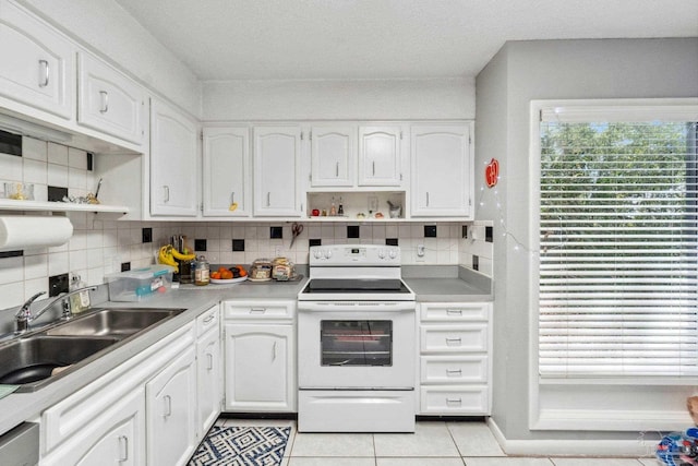 kitchen featuring sink, white cabinets, electric stove, decorative backsplash, and light tile patterned floors