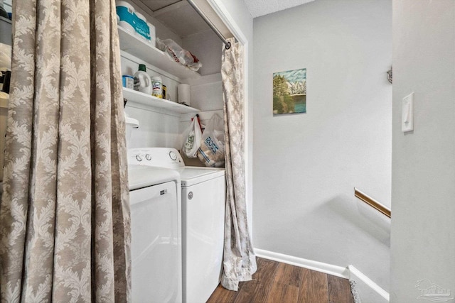 clothes washing area featuring a textured ceiling, dark hardwood / wood-style floors, and washing machine and clothes dryer