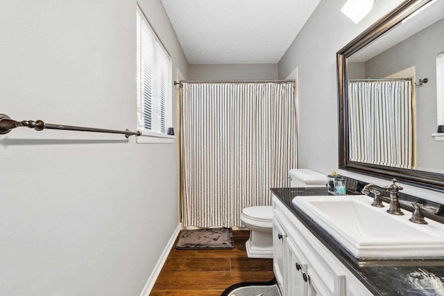 bathroom featuring vanity, toilet, a textured ceiling, walk in shower, and hardwood / wood-style floors