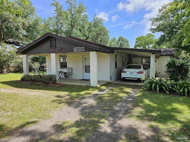 view of front of property with a front lawn, a carport, and a porch