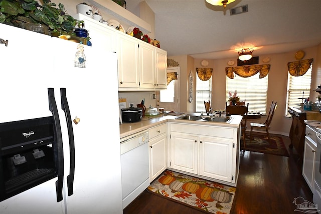 kitchen with kitchen peninsula, sink, white cabinets, white appliances, and dark hardwood / wood-style flooring