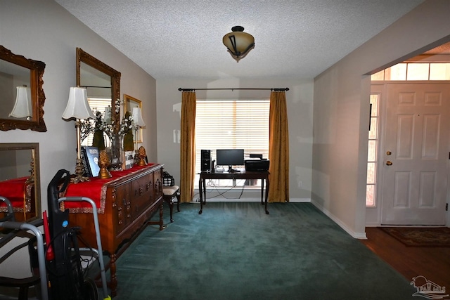 carpeted foyer with a textured ceiling