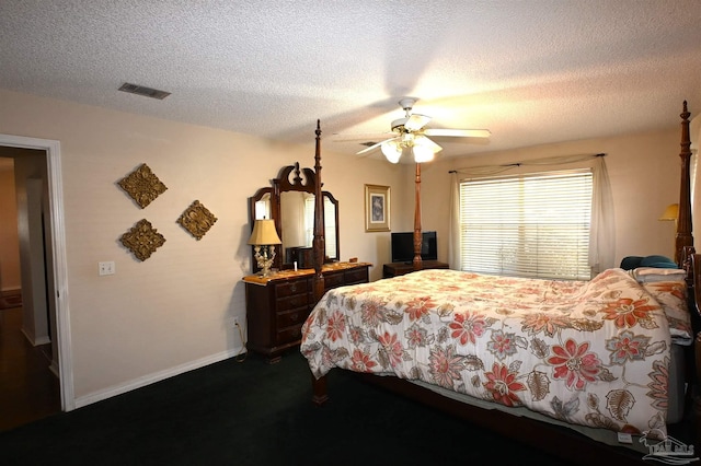 bedroom with ceiling fan, a textured ceiling, and dark colored carpet