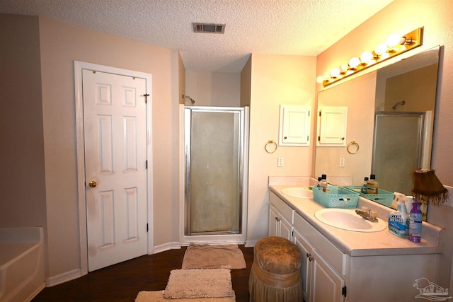 bathroom with vanity, a textured ceiling, wood-type flooring, and separate shower and tub