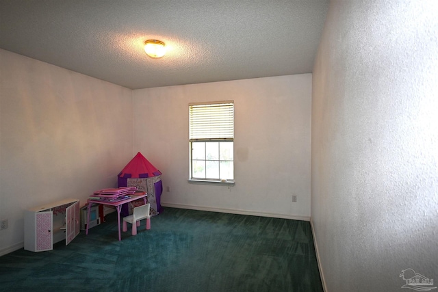 rec room with a textured ceiling and dark carpet