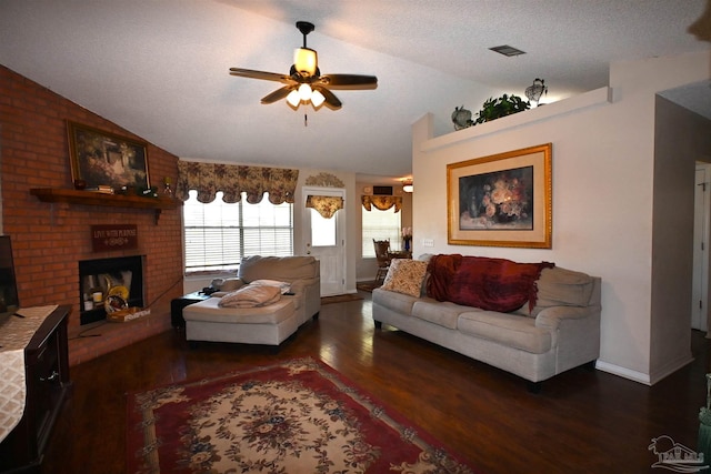 living room featuring a textured ceiling, dark hardwood / wood-style flooring, a brick fireplace, ceiling fan, and lofted ceiling