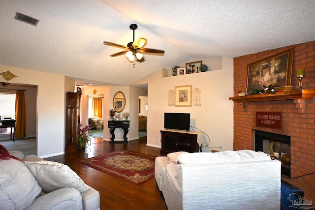 living room featuring lofted ceiling, a brick fireplace, ceiling fan, a textured ceiling, and dark hardwood / wood-style flooring