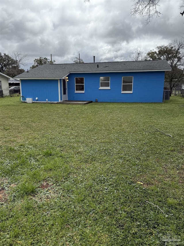 rear view of house featuring a yard