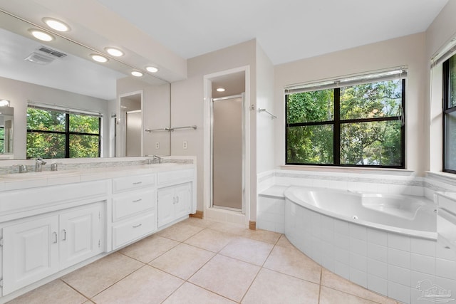 bathroom featuring a sink, a healthy amount of sunlight, tile patterned floors, and double vanity