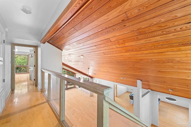 hallway with an upstairs landing, wood ceiling, and wood-type flooring