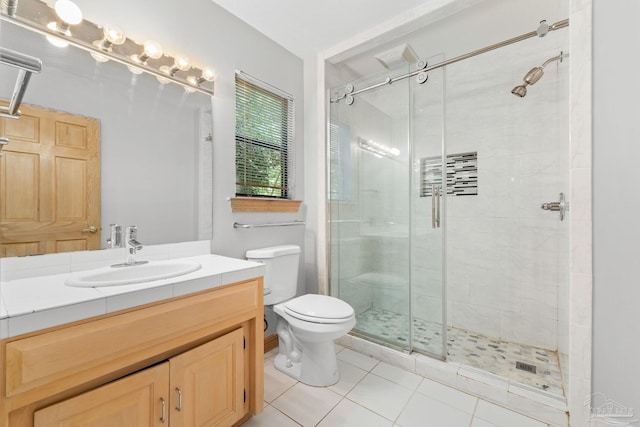 bathroom featuring toilet, a stall shower, vanity, and tile patterned flooring