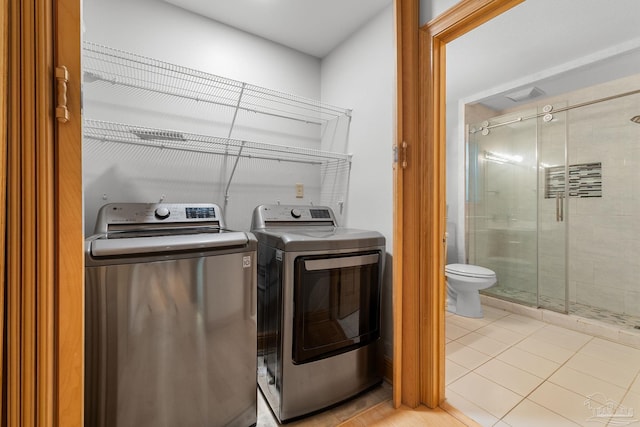 laundry area featuring washer and dryer, laundry area, and light tile patterned floors