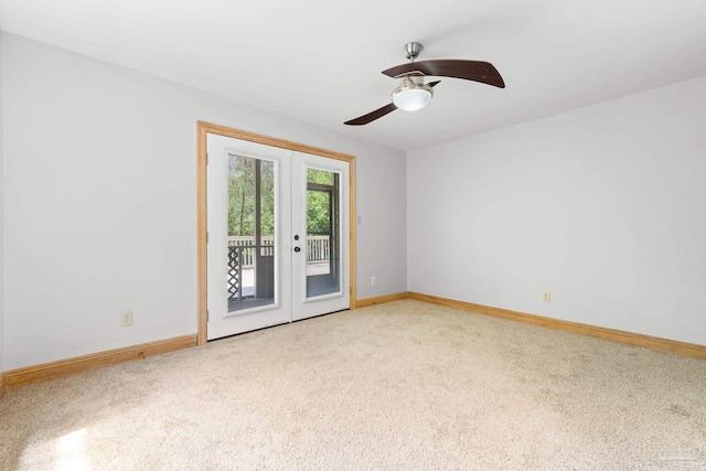 empty room with a ceiling fan, french doors, light colored carpet, and baseboards