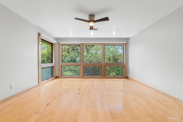 spare room with visible vents, baseboards, wood finished floors, and a ceiling fan