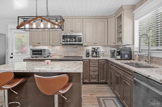 kitchen with decorative backsplash, a sink, stainless steel appliances, and a toaster