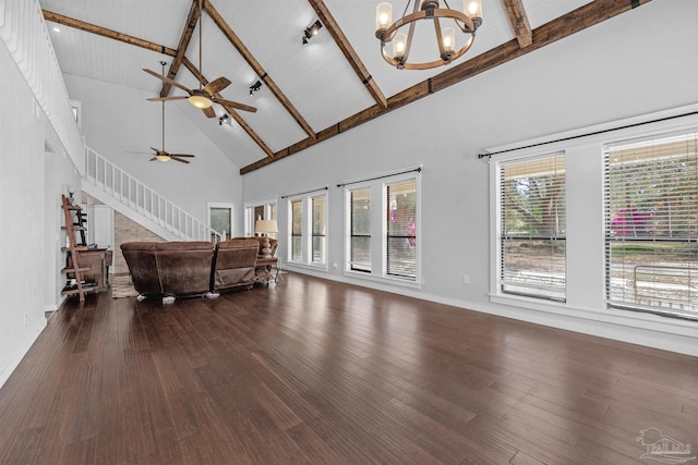 living area featuring dark wood-type flooring, high vaulted ceiling, ceiling fan with notable chandelier, and a wealth of natural light