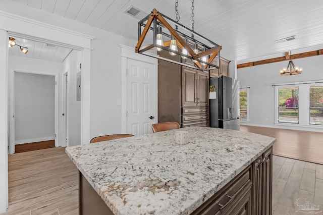 kitchen featuring a notable chandelier, light stone counters, wooden ceiling, stainless steel fridge, and light wood-style flooring