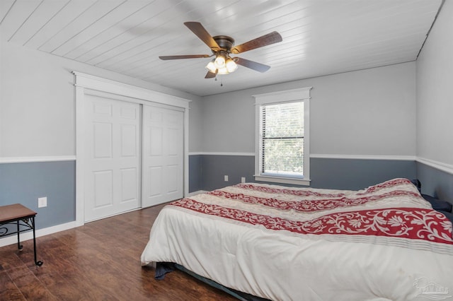 bedroom with a closet, dark wood-style flooring, baseboards, ceiling fan, and wood ceiling