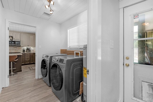 washroom with washer and dryer, laundry area, and light wood-type flooring