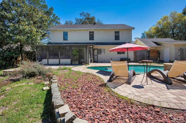 pool with fence, a sunroom, and a patio area