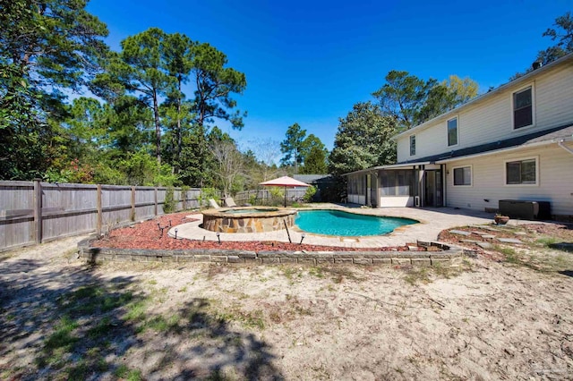 view of pool featuring a sunroom, a fenced in pool, a fenced backyard, and a patio area