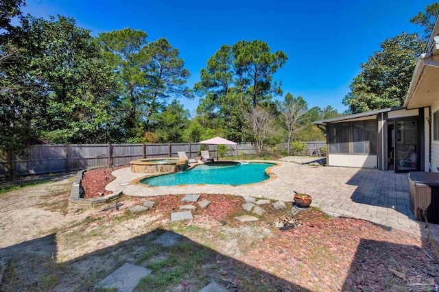 view of swimming pool with a fenced backyard, a pool with connected hot tub, a sunroom, and a patio