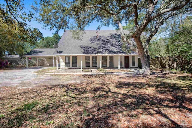 view of front of property with an attached carport, fence, and driveway