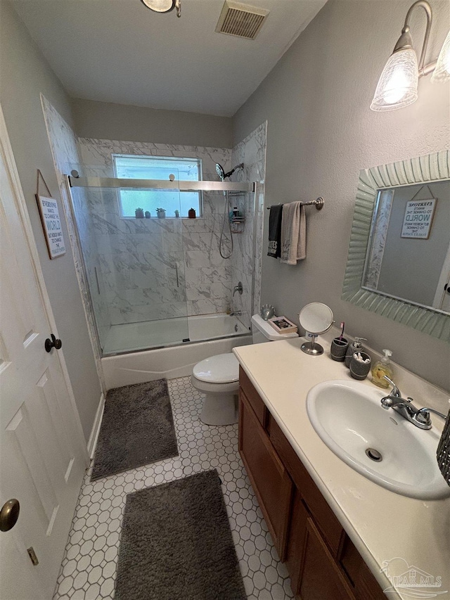 full bathroom featuring enclosed tub / shower combo, vanity, and toilet