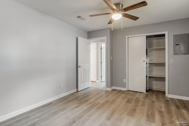 unfurnished bedroom featuring a closet, ceiling fan, electric panel, and light wood-type flooring